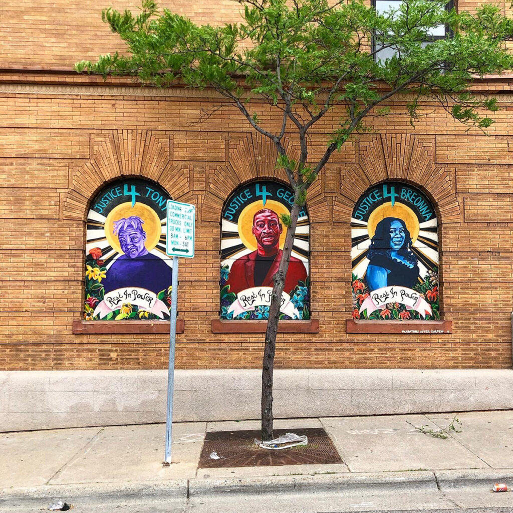 Three portraits on boarded-up windows of Tony McDade, George Floyd, and Breonna Taylor with the words "rest in power" under each colorful portrait.